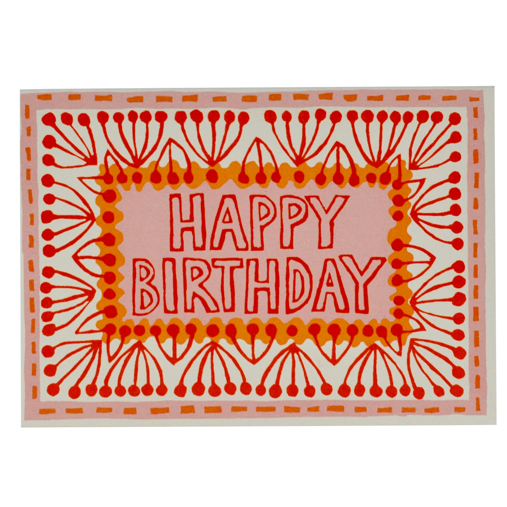 An ivory card with a bold orange and red printed design around the edge, with the words 'happy birthday' in the middle. Designed by Cambridge Imprint