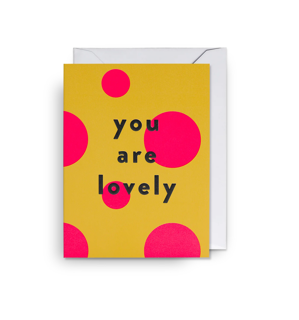 Yellow mini greetings card with pink polka dots and black text that reads 'You are lovely', designed by Lagom.
