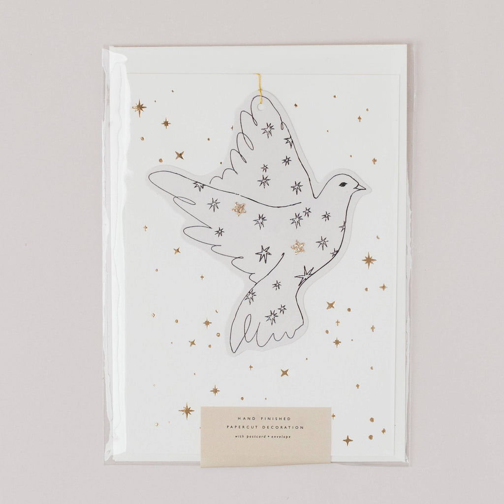 Decorative paper cutout of a dove with stars on a white background