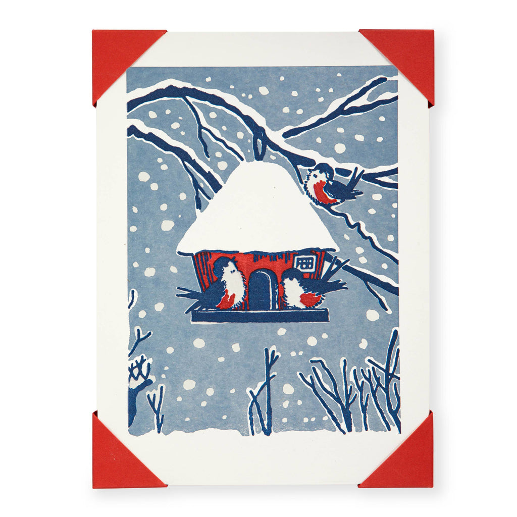 Card with a snowy landscape design featuring a house and birds, framed with red corners.