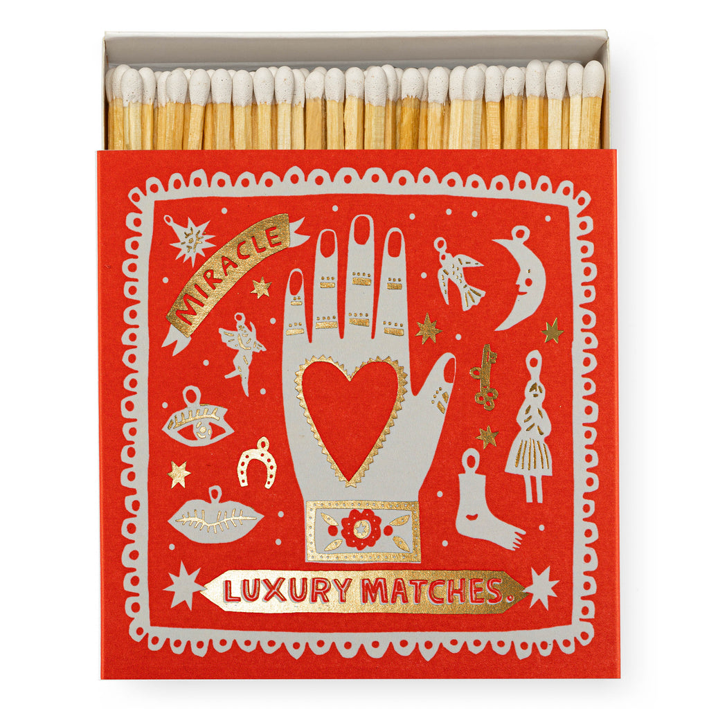 Luxury box of matches by Archivist, featuring a bold red design and gold foil detailing, with folk-style charms on the front and text that reads 'Miracle - Luxury Matches'