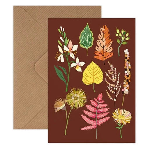 'Autumn Begins' card by Brie Harrison, featuring oak leaves and other autumnal leaves and flowers, on a deep brown background.
