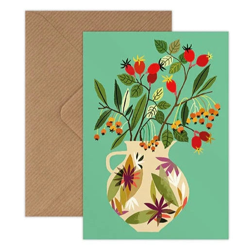 Greetings card illustrated by Brie Harrison, featuring a decorative vase filled with rosehip stems on a green background. Shown with corresponding kraft brown envelope.