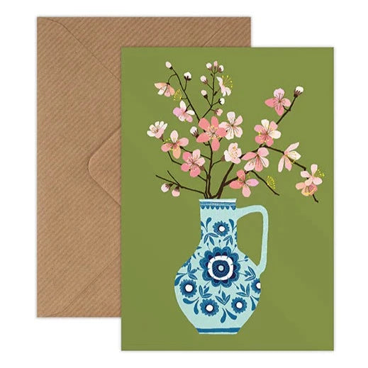 Illustrated card by Brie Harrison, featuring cherry blossom branches in a blue floral jug on a pea green background. With a corresponding kraft brown envelope.