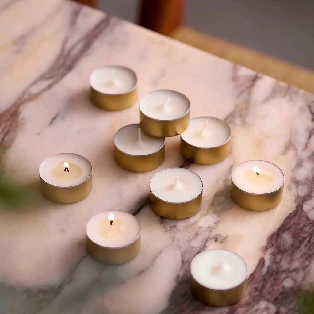 Gold and white candles on a marble surface