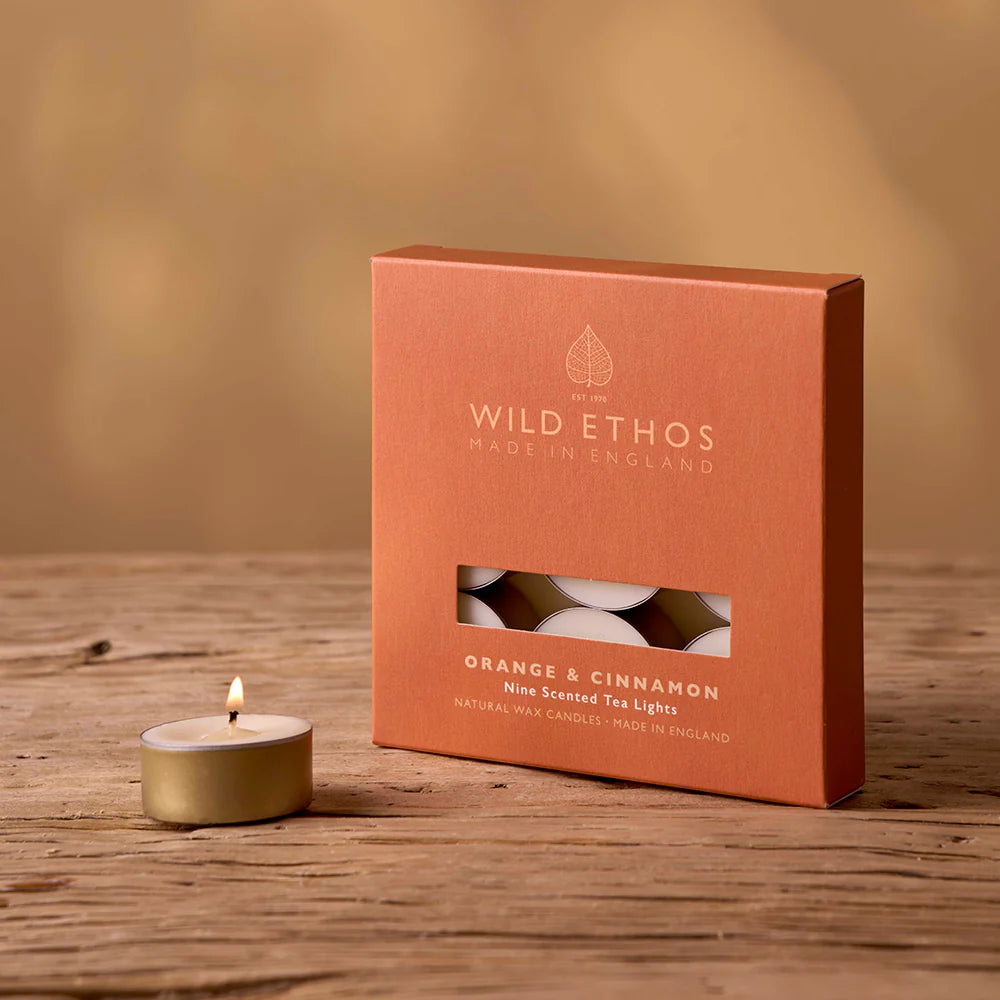Box of Wild Ethos Orange & Cinnamon tea lights on a wooden surface