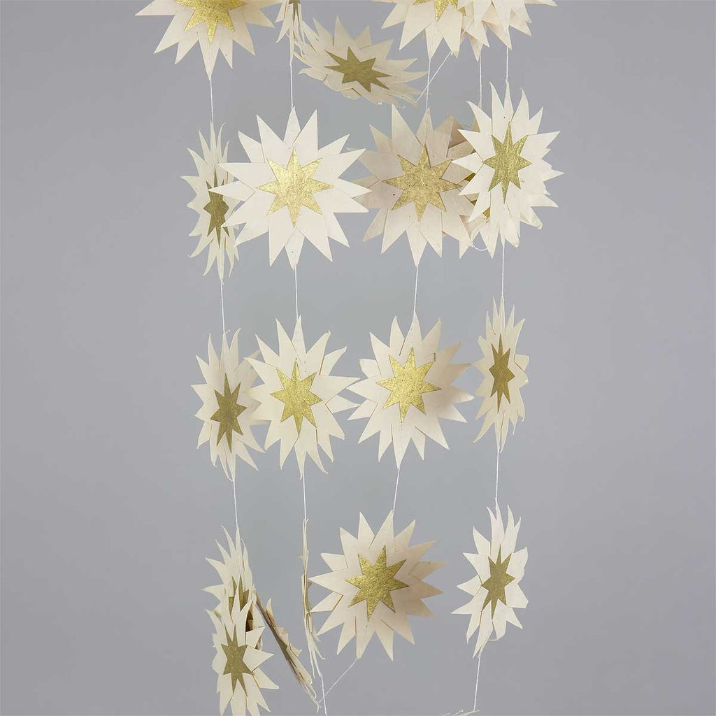 Decorative string of white and gold paper stars on a gray background