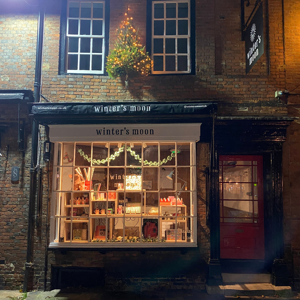 Gift shop store front at night dressed for Christmas. 
