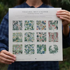 Person holding a gardening calendar with vegetable, fruit, and flower designs.