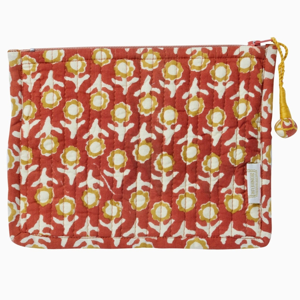cotton pouch with a block printed terracotta flower pattern and a zip pull