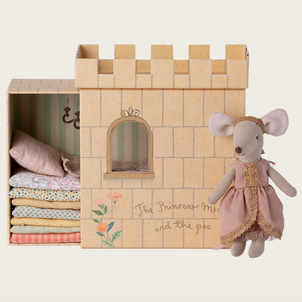 Toy castle with bedding and a plush mouse toy on a white background