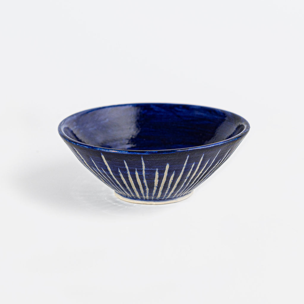 Navy blue handmade stoneware bowl, with striped pattern.