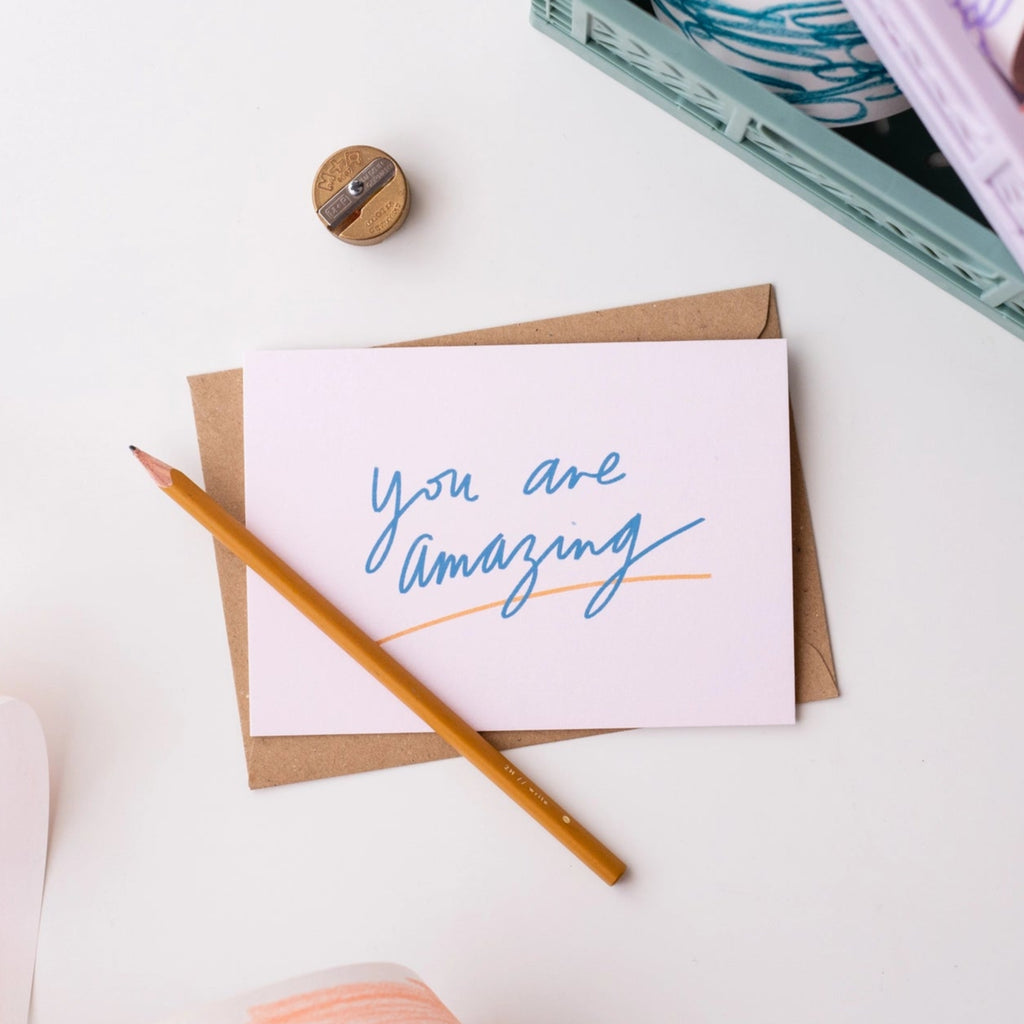 Pale pink greetings card with 'You are amazing' text in blue with a yellow underline.