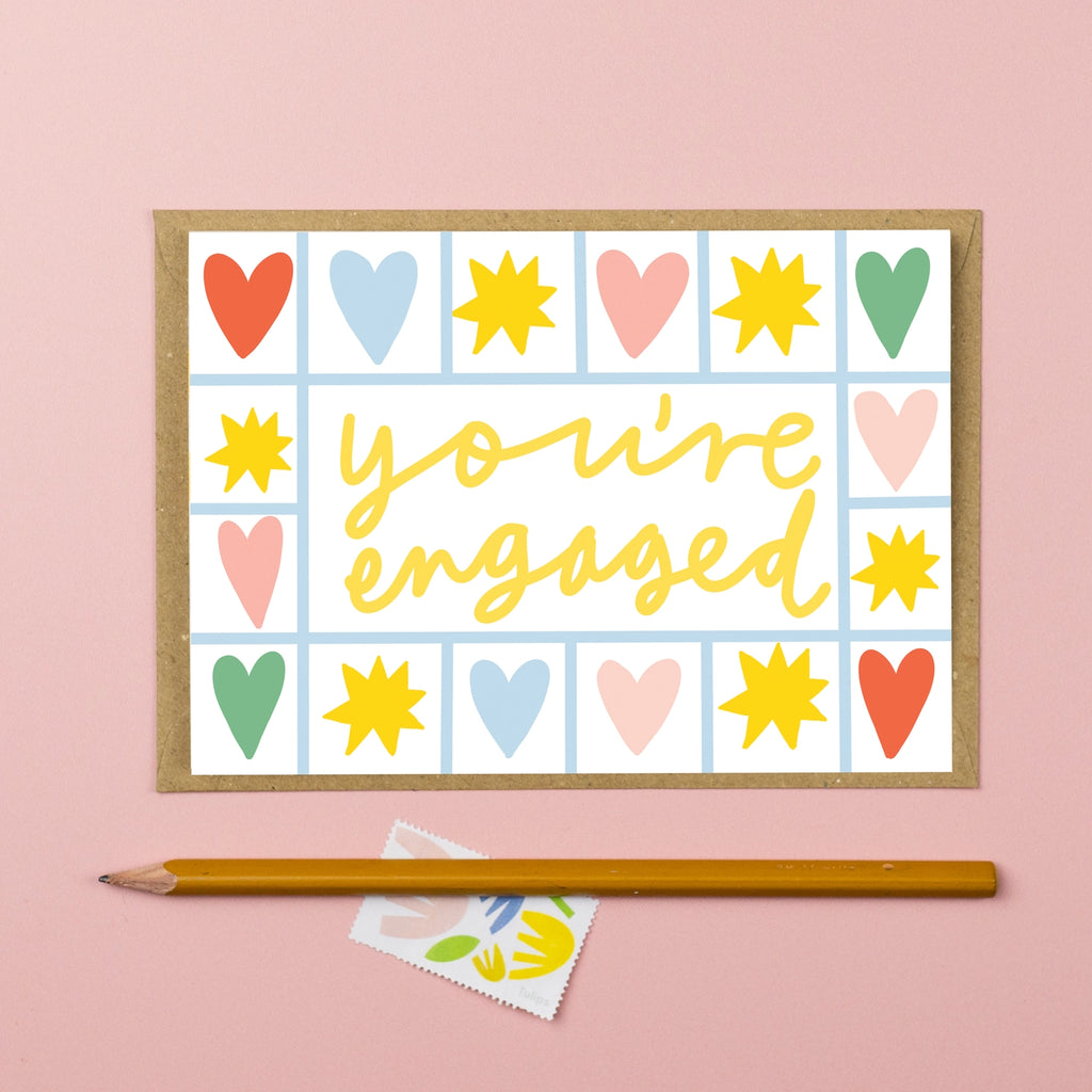 Card with 'you're engaged' text and colorful hearts and suns on a white background