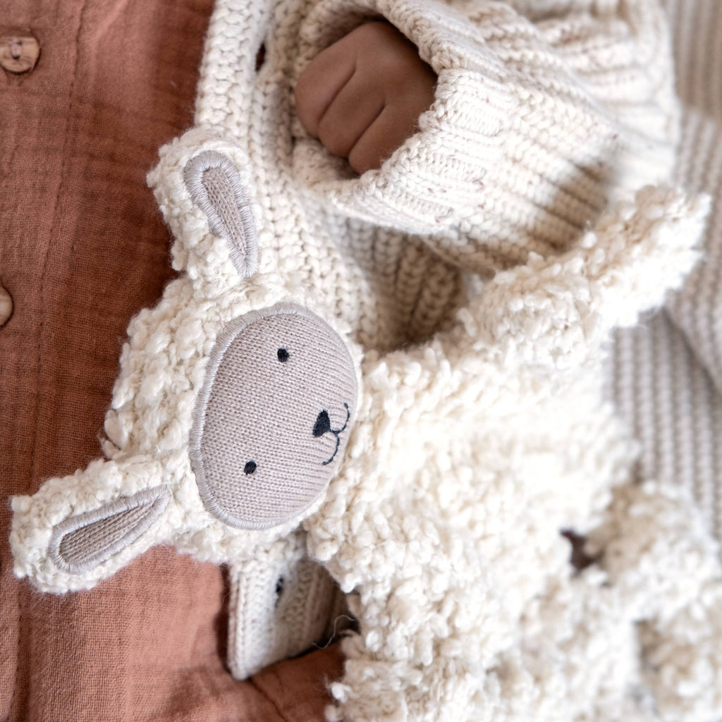 Sheep comforter baby toy held by baby