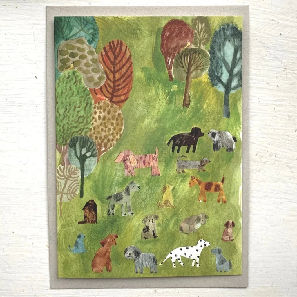 An A6 card created by Leeds-based artist Nicola Clarke and featuring a green, park scene with trees and dogs. 