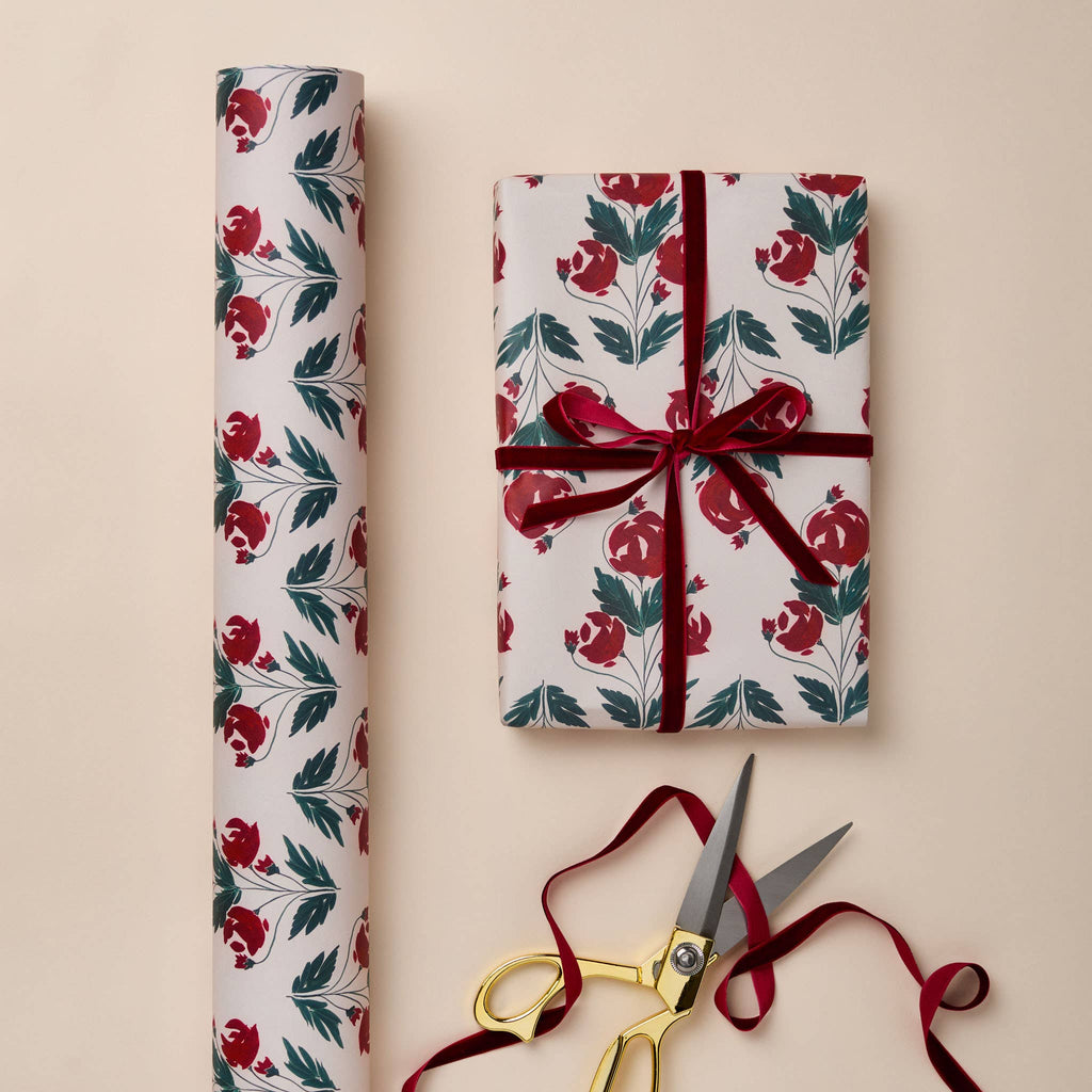 Floral-patterned gift wrap with a wrapped present and scissors on a beige background