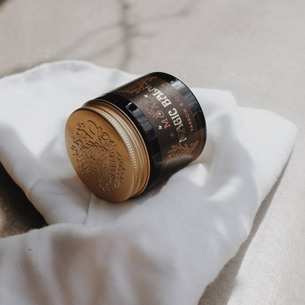 Jar of skin product on a white cloth with a neutral background