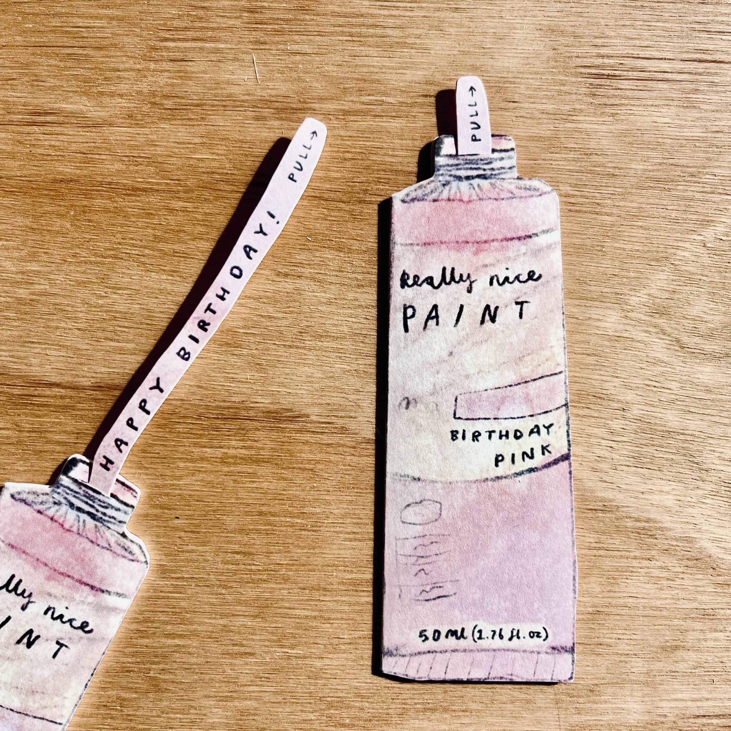 laura skilbeck - paper tube of 'birthday' pink paint with pull-out tab that says 'happy birthday' - winter's moon