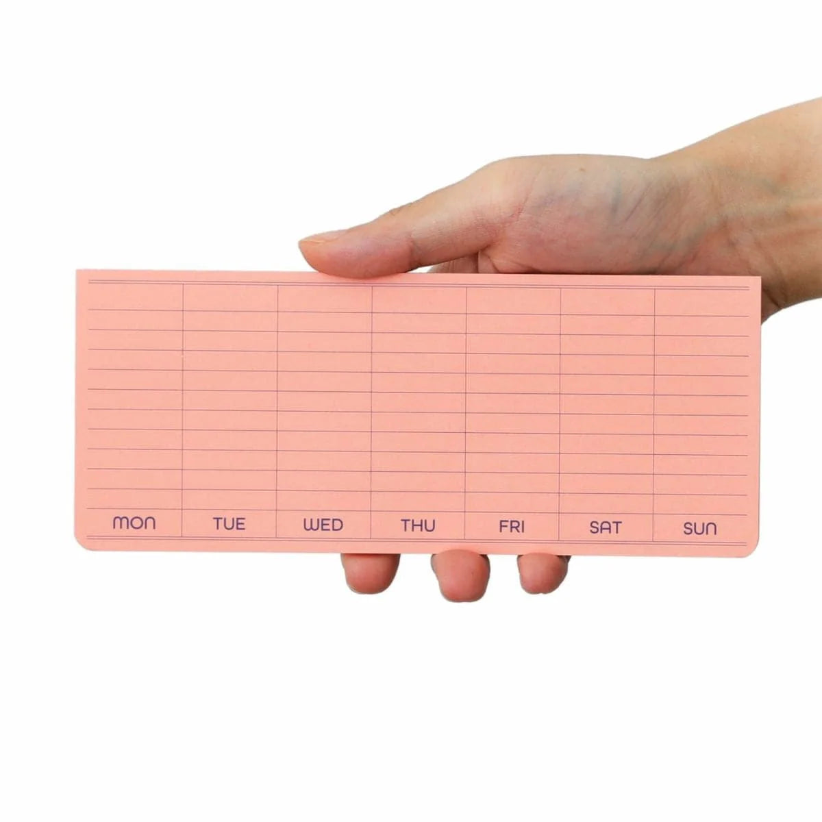 Hand holding a pink weekly planner with days of the week on a white background