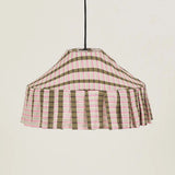 Fabric pendant lampshade with a khaki and pink mosaic pattern, hanging against a cream background
